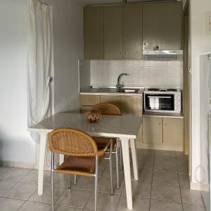 尼亚·蒙达尼亚Pansion Argo的厨房配有桌椅和水槽