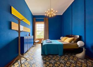 San Andres y SaucesHostal Bubango的一间蓝色卧室,配有一张床和一个吊灯