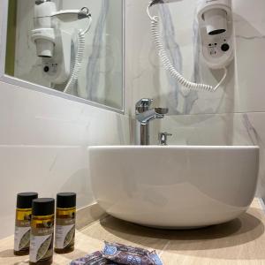 尼亚·蒙达尼亚Pansion Argo的浴室设有白色水槽和镜子
