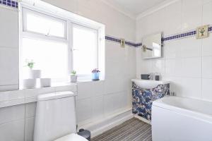 巴塞尔顿Elegant 3 Bedroom House in Basildon - Essex Free Parking & Superfast Wifi, upto 6 Guests的白色的浴室设有卫生间和窗户。