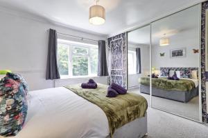 巴塞尔顿Elegant 3 Bedroom House in Basildon - Essex Free Parking & Superfast Wifi, upto 6 Guests的一间卧室配有一张大床和镜子