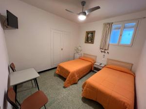 桑特费柳德吉克索尔斯Hostal Zurich的配有橙色床单的客房内的两张床