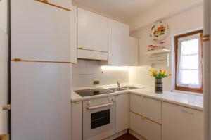 科尔蒂纳丹佩佐Appartamento centralissimo con wi-fi的白色的厨房配有白色橱柜和水槽