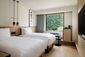 MotegiFairfield by Marriott Tochigi Motegi的配有窗户的酒店客房内的两张床