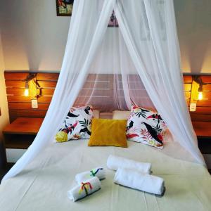 因巴塞Casa noites tropicais的一张带天蓬的床,上面有两条毛巾