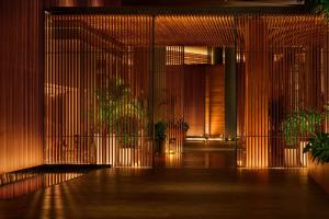 三亚三亚艾迪逊酒店的建筑中带有木墙和植物的走廊