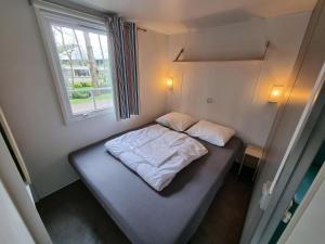 哈登贝赫Chalet vakantiepark Kleine Belties 18的一个小房间的小床,设有窗户