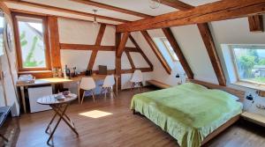 博登斯边的伊门施塔特Waldvogel Ferienzimmer klimatisiert的一间带绿色床的卧室,位于带木梁的房间