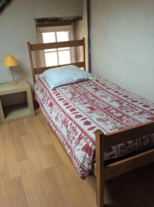 Chambres d'hôtes au calme的一间卧室配有一张带红白毯子的床