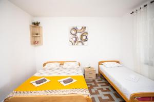 乌尔齐尼Apartments Jelena Ulcinj的白色墙壁客房中的两张单人床