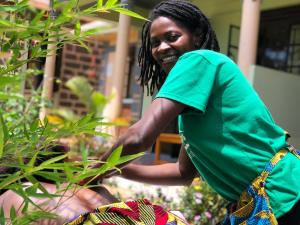 KapchorwaHome of Friends的站在植物旁的绿色衬衫上的女人