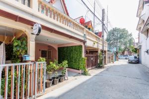 大城Baan Mee Suk Ayutthaya的街道边有植物的建筑