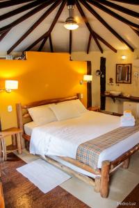 佩尼多露娜别墅旅馆的一间卧室设有一张黄色墙壁的大床