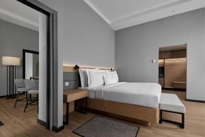 峇六拜AC Hotel by Marriott Penang的酒店客房带一张床铺、一张书桌和一间卧室