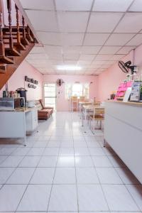 大城Baan Mee Suk Ayutthaya的厨房拥有粉红色的墙壁和白色的瓷砖地板。
