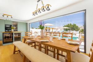 普拉亚布兰卡Villa Olive Tree的一间带木桌和大窗户的用餐室