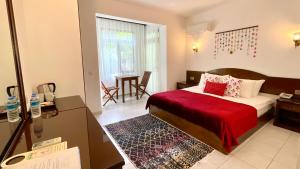 契拉勒爱达酒店的酒店客房,配有一张带红色毯子的床