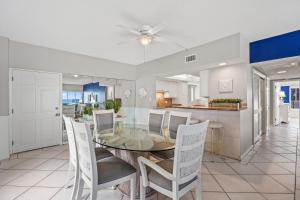 西耶斯塔岛Island House Beach Resort 3S的用餐室以及带玻璃桌和椅子的厨房
