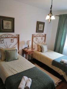 特格斯特Villa La Victoria的一间卧室配有两张带毛巾的床