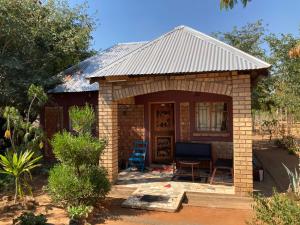 KazungulaNakawa Community Campsite的一座带门廊和庭院的小砖屋