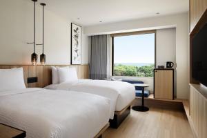 MihamaFairfield by Marriott Mie Kumano Kodo Mihama的配有窗户的酒店客房内的两张床