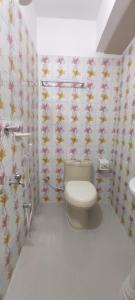 达卡Hotel Prime Inn Mirpur 10的浴室配有卫生间,墙上挂有鲜花
