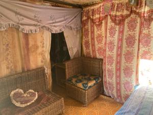KazungulaNakawa Community Campsite的配有床、椅子和窗帘的房间