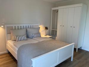 劳特尔巴赫Ferienwohnung Hafentraum, Villa Vilmblick mit Strandkorb的卧室配有一张带两个枕头的大白色床