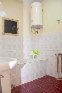 努瓦克肖特Jolie Maison的浴室配有水槽和浴缸上的椅子