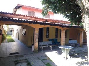 伯迪亚哥Hostel Canto de Bertioga的房屋的庭院,配有长凳和桌子