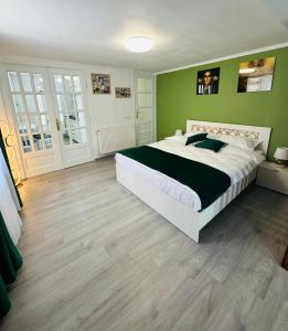 锡比乌Luxor Apartament Sibiu的一间卧室设有一张大床和绿色的墙壁