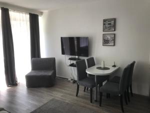 科隆City Apartment am Dom的客厅配有桌椅和电视。