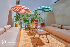 卡萨布兰卡Stayhere Casablanca - CIL - Vibrant Residence的客厅配有两张沙发和两把遮阳伞