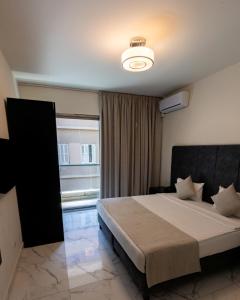 贝鲁特东方女王之家公寓式酒店 的一间卧室设有一张大床和一个窗户。