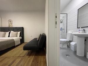 地拉那Central Studio Apartments的一间卧室配有一张床,浴室设有水槽