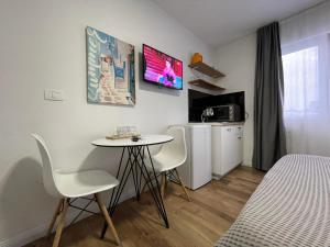 地拉那Central Studio Apartments的配有桌椅和床的房间