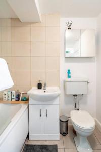 雷丁Perfect for Large Family & Friends, Free Parking, Games的白色的浴室设有卫生间和水槽。