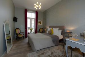 波尔多Au Coeur de Bordeaux B&B的一间卧室配有一张床、一张桌子和一面镜子