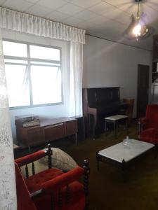 库里提巴Quartos em Casa próximo ao Parque Bacacheri的带沙发和钢琴的客厅