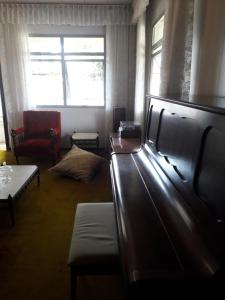 库里提巴Quartos em Casa próximo ao Parque Bacacheri的一间带沙发和椅子的客厅