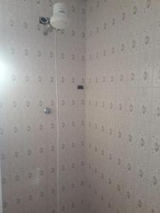 库里提巴Quartos em Casa próximo ao Parque Bacacheri的带淋浴的浴室和白色瓷砖墙