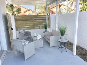 迈阿密Modern & New,Excellent Location Miami的庭院设有藤椅、桌子和长凳