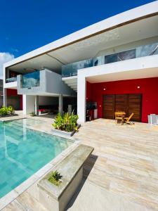 帕拉茹鲁Vila Kite Lagoon的一座带游泳池和红墙的房子