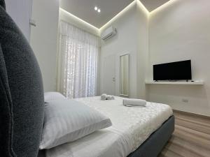 那不勒斯Luxury B&B Sun Art Naples的一间白色卧室,配有床和电视