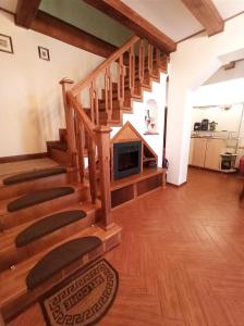 道泽兹西特里奥格Pensiunea Roșu Litoral的客厅设有带壁炉的木制楼梯