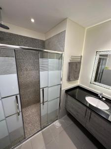 索瓦马Dead Sea view Elite apartment Samara Resort traveler award 2024的一间带玻璃淋浴和水槽的浴室