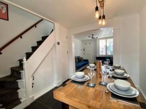 布莱顿霍夫Camelford Street Cottage - Brighton的一间带木桌和楼梯的用餐室