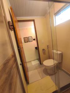 戈亚斯州上帕莱索Chalé com ar condicionado e garagem的一间带卫生间和玻璃门的浴室