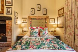 埃姆斯伯里The George Hotel, Amesbury, Wiltshire的一间卧室配有一张带花卉床罩的床