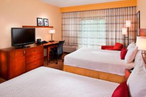 墨尔本墨尔本西万怡酒店的酒店客房设有两张床和一张书桌及电视